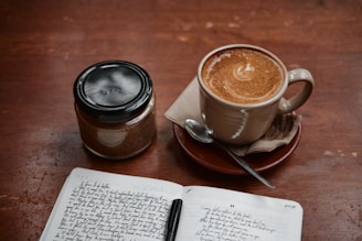 white ceramic mug on saucer beside silver spoon