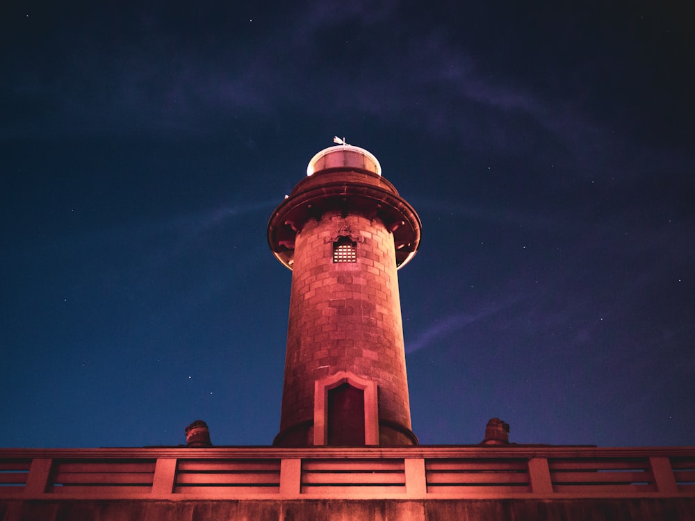 torre di cemento marrone e bianco sotto il cielo blu durante la notte
