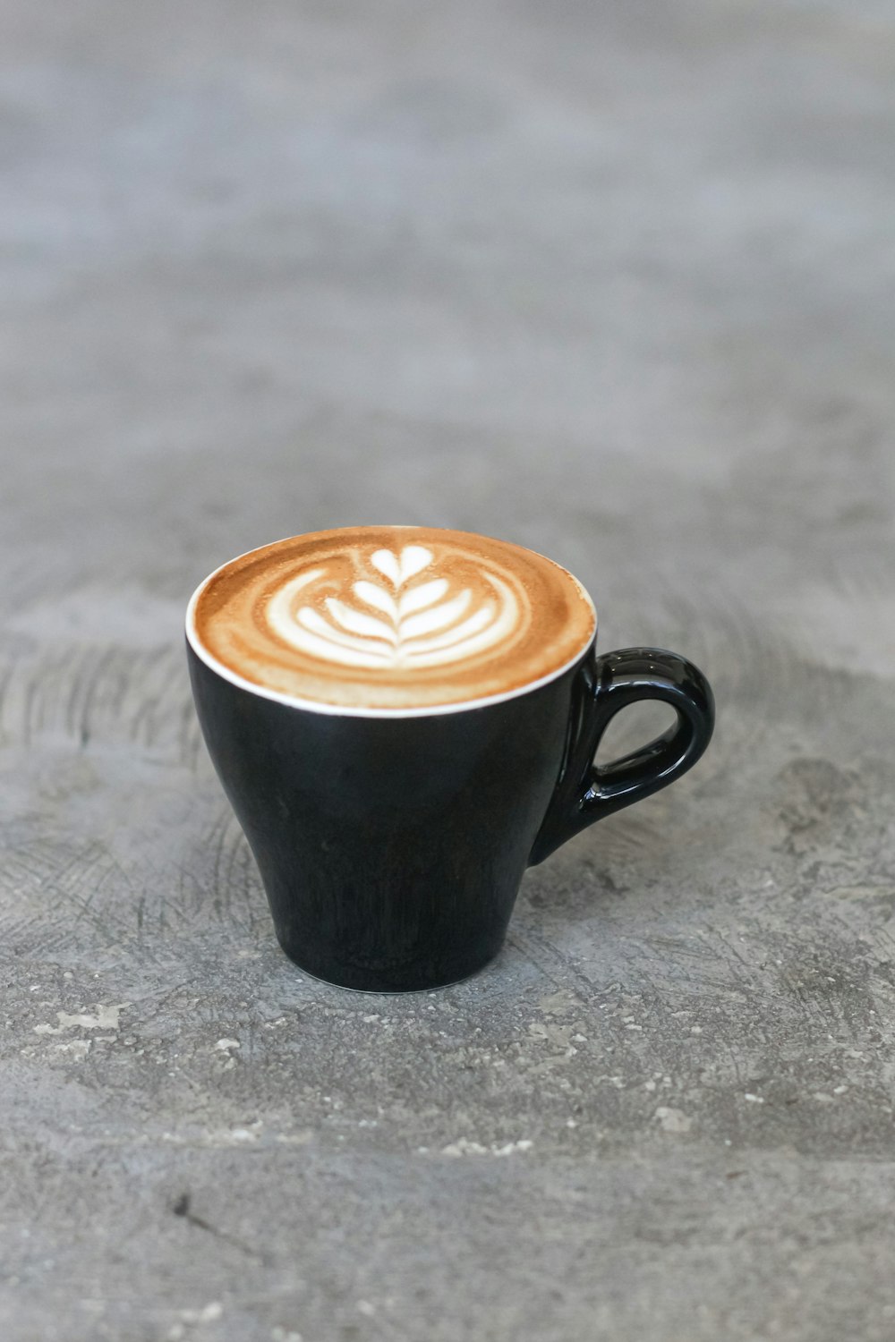 Mug en céramique noire avec liquide brun et blanc