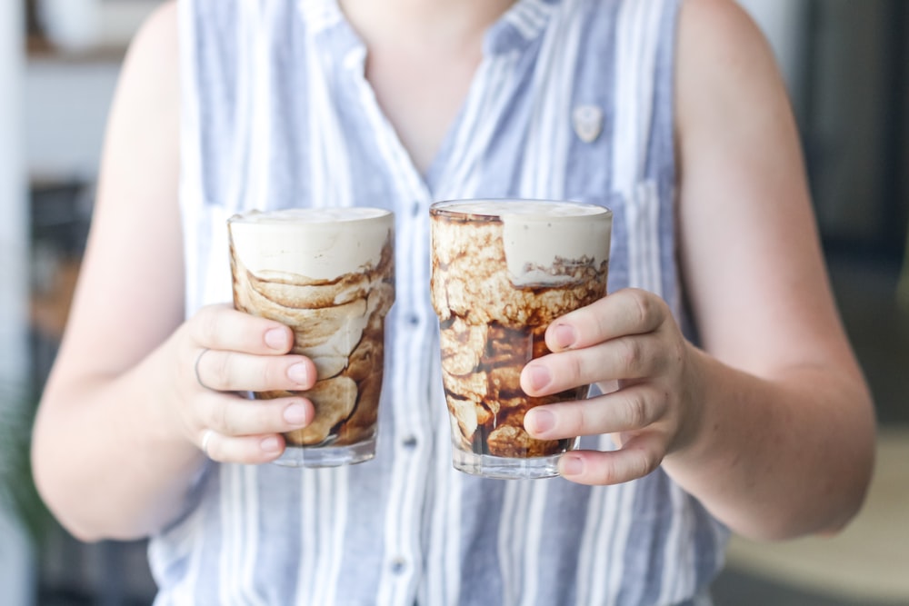 woman in white button up shirt holding clear drinking glass