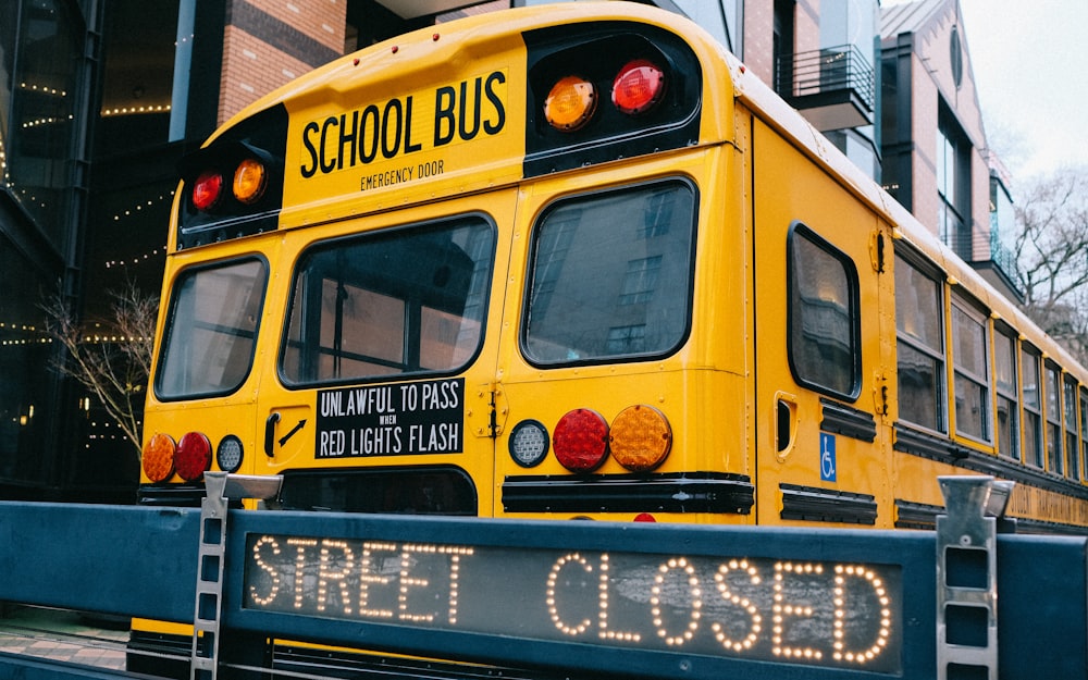 日中の道路を走る黄色いスクールバス