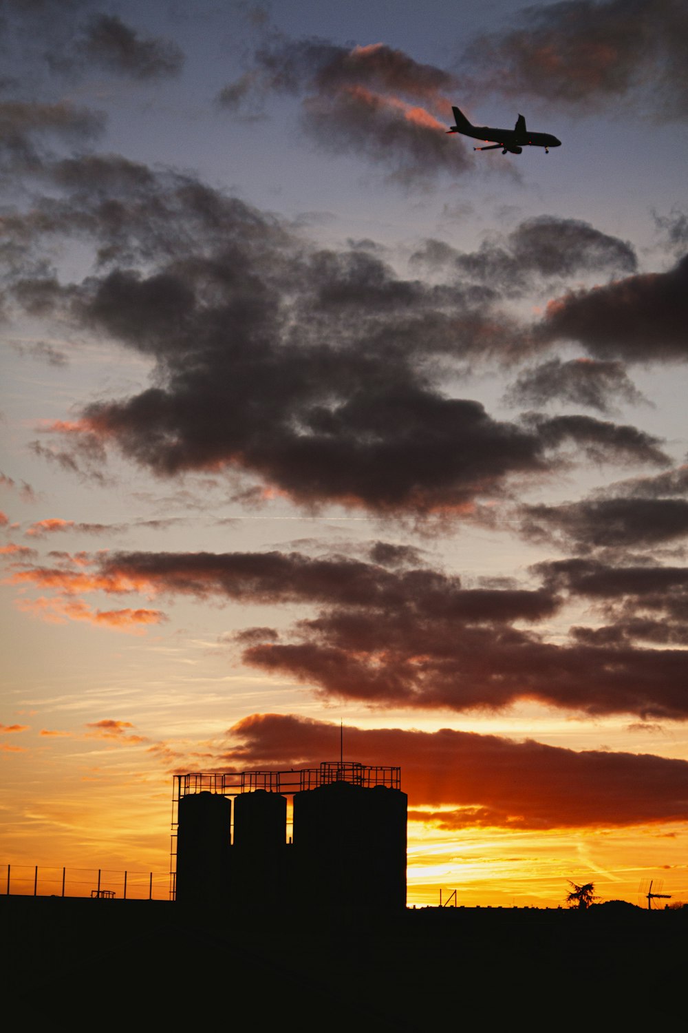 silhouette of building under cloudy sky during sunset