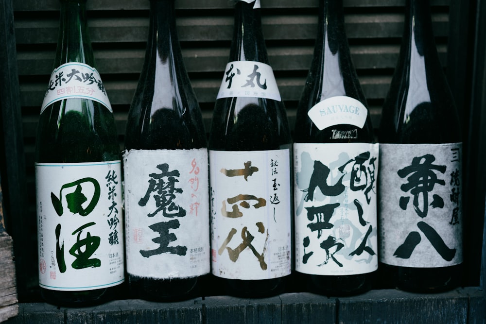 white and black bottles on black wooden shelf