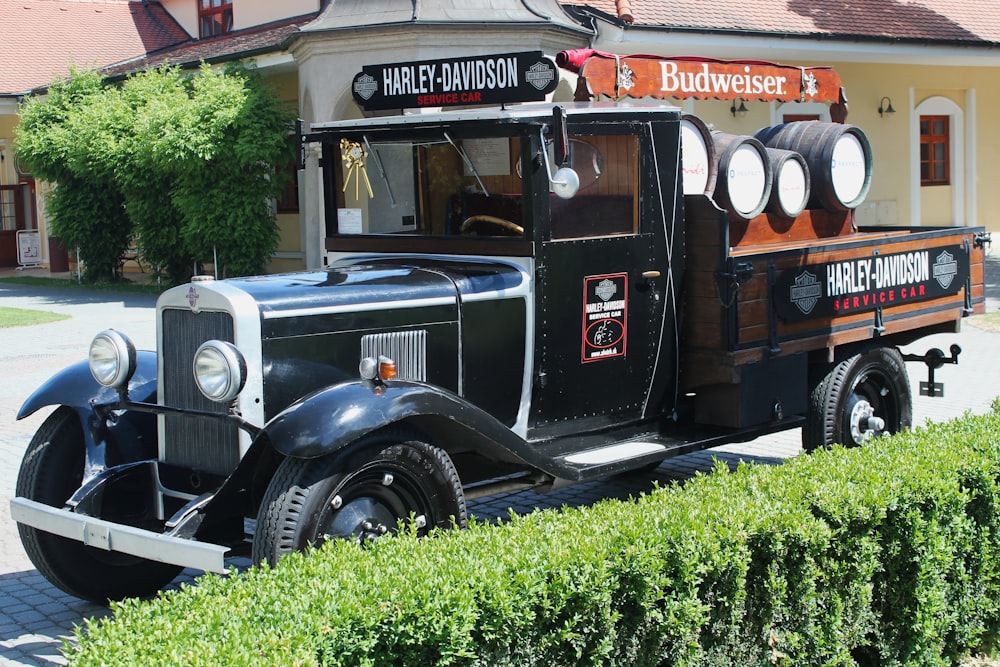 vintage black and brown car parked beside green grass during daytime