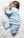 woman in teal pajama lying on bed