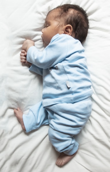 woman in teal pajama lying on bed