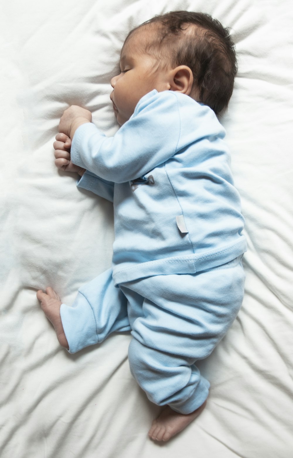 woman in teal pajama lying on bed