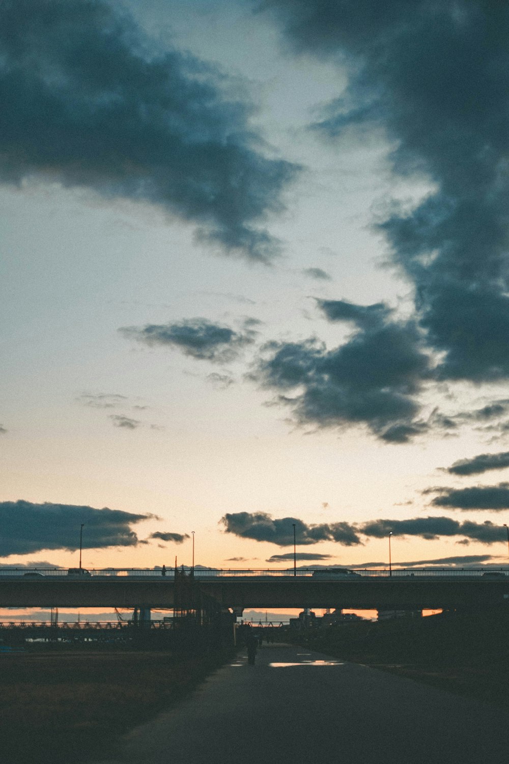 silhouette of bridge under cloudy sky during daytime