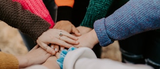 person in red sweater holding babys hand