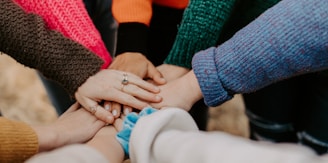 person in red sweater holding babys hand