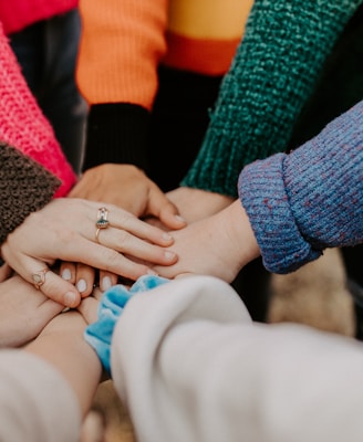 person in red sweater holding babys hand