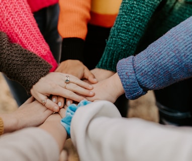 person in red sweater holding babys hand