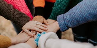 person in red sweater holding babys hand