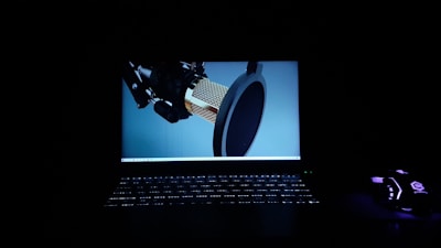 A sleek dark-themed studio microphone setup with Urdu script glowing softly in the background.
