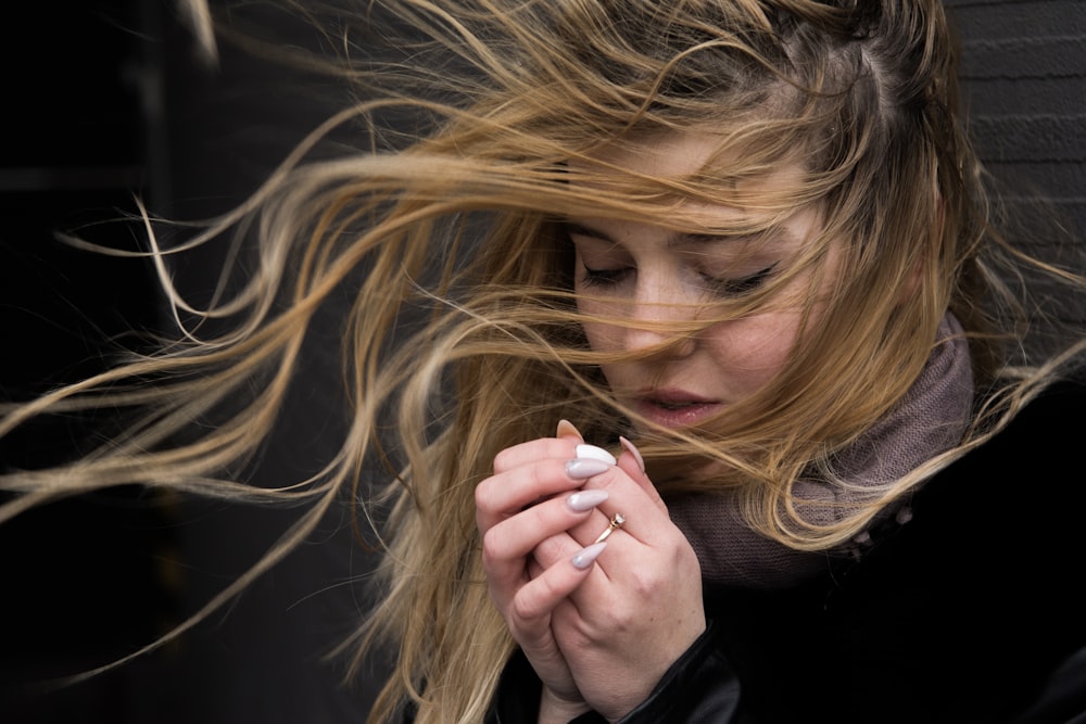 woman in black long sleeve shirt holding her hair