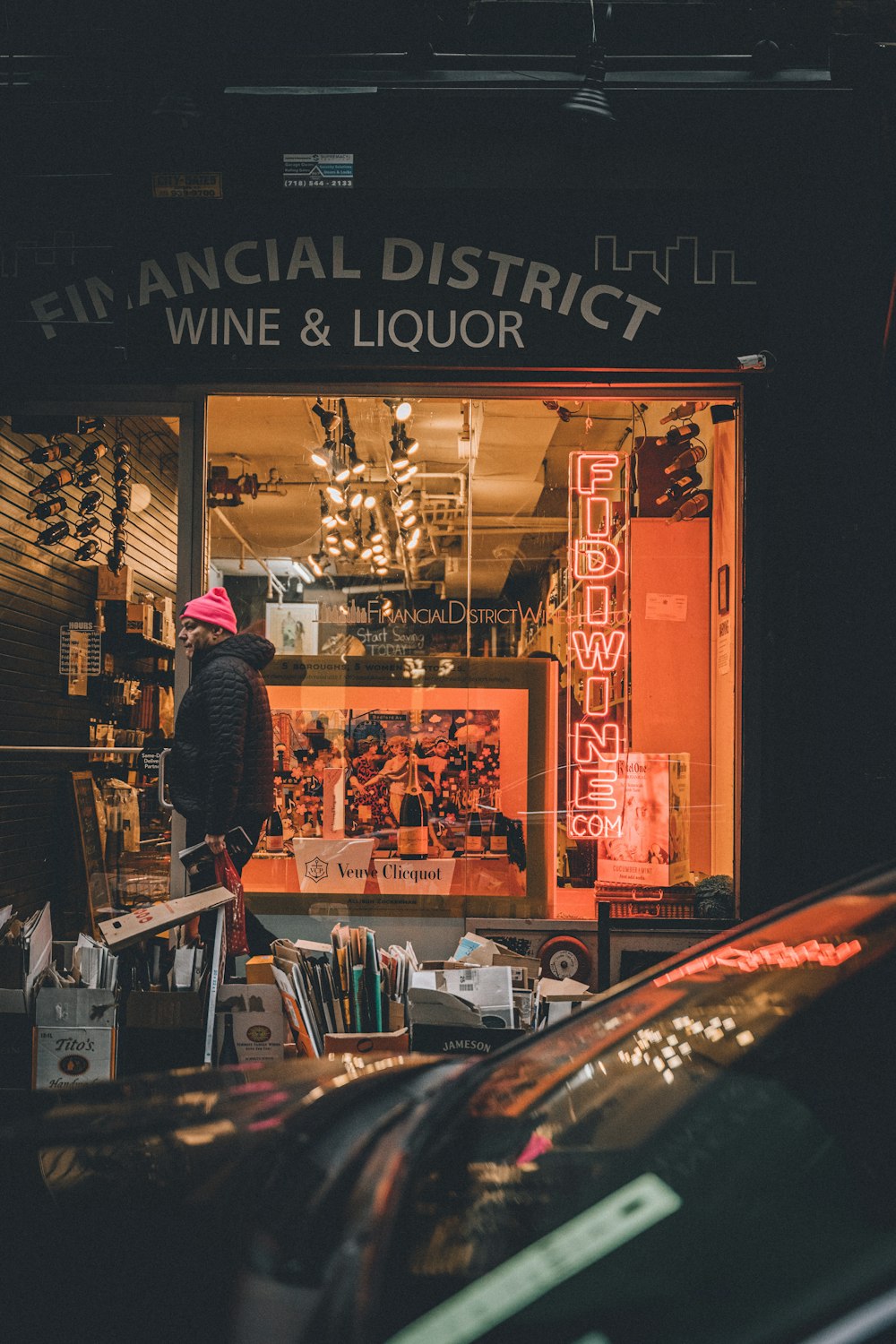 man in purple jacket standing in front of store