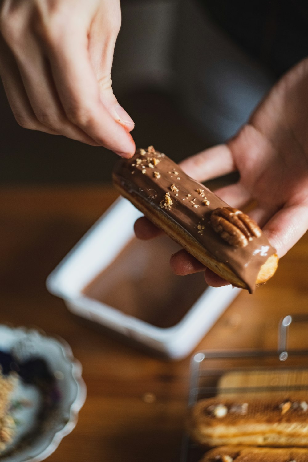 person holding chocolate bar with chocolate syrup