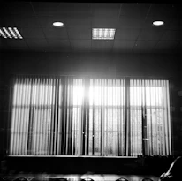 A bright room featuring sleek roller blinds partially drawn to control light.