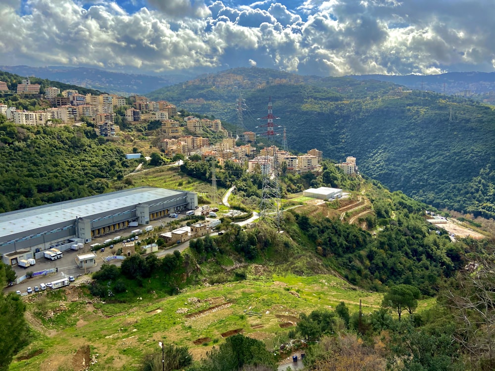 white concrete building on green mountain under white clouds during daytime