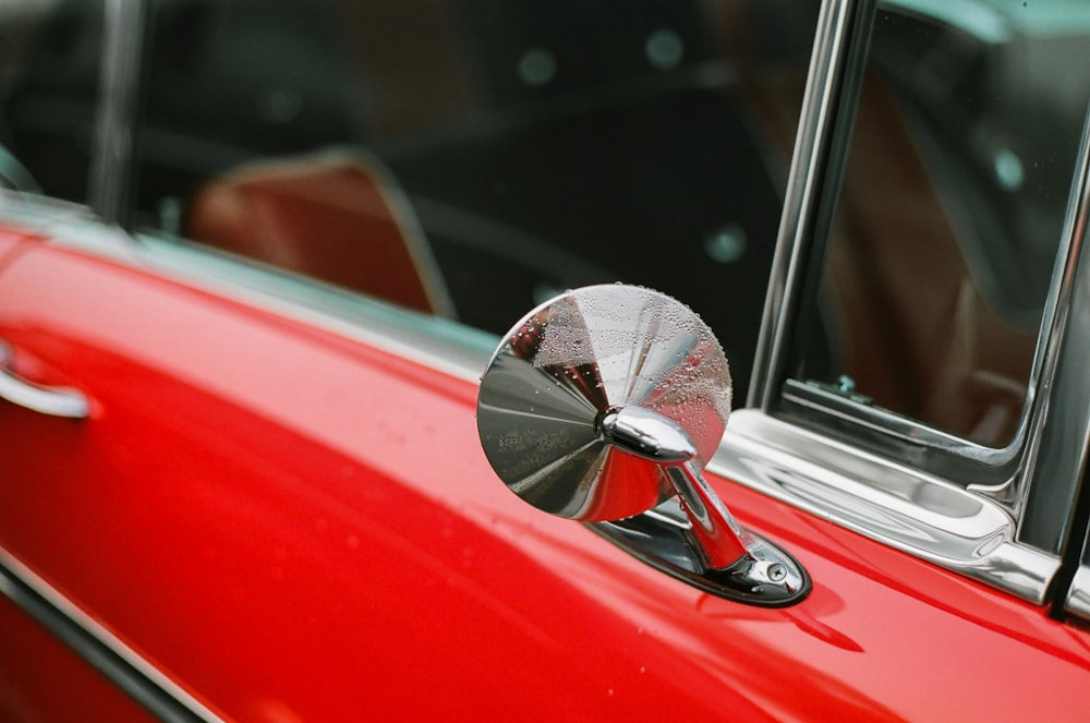 red car side mirror with water droplets