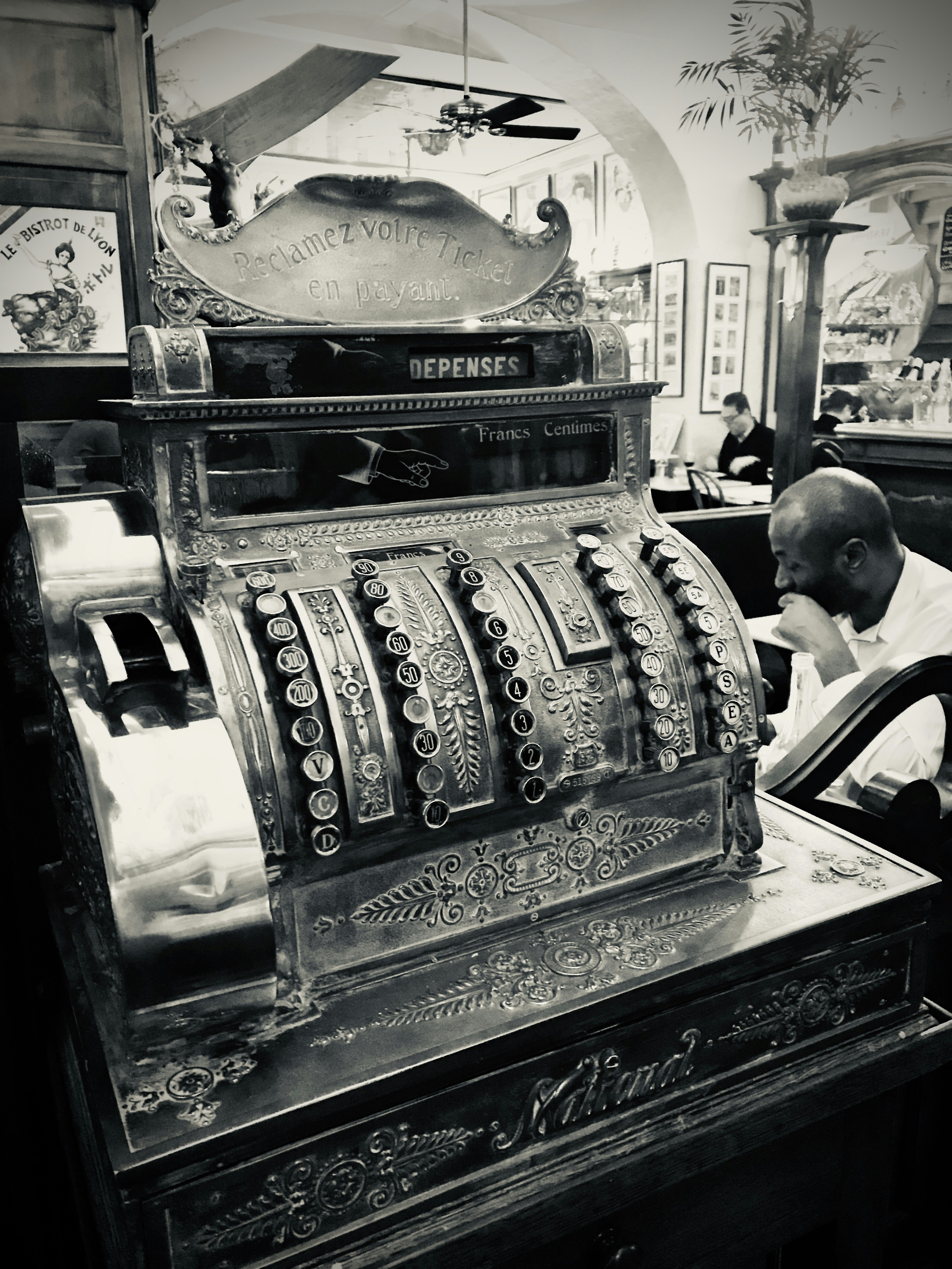 man in black suit standing beside brown and black wooden desk