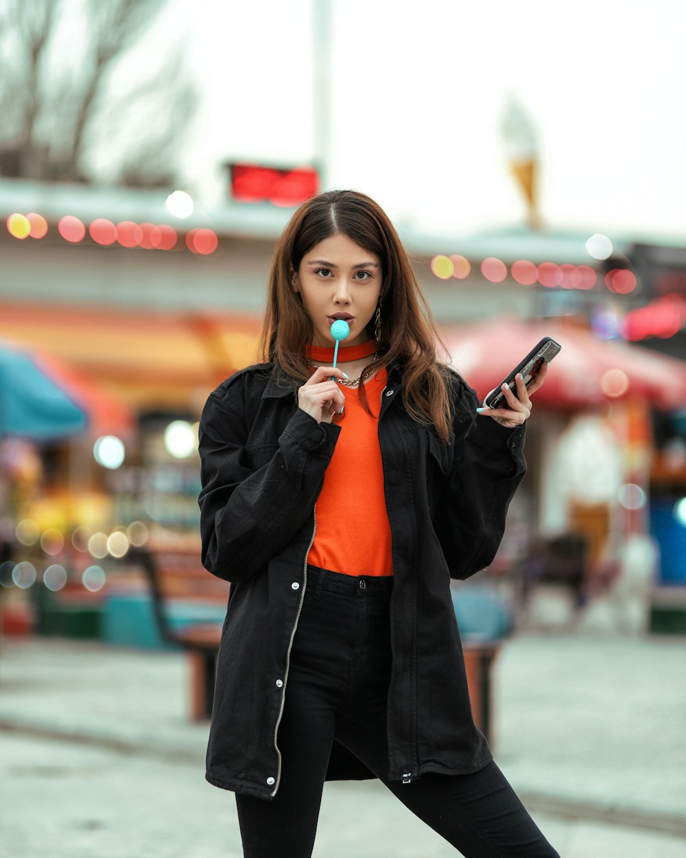 woman in red blazer holding smartphone