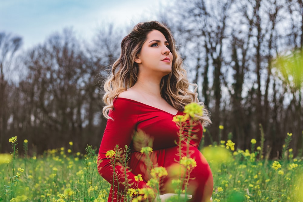 woman in red off shoulder dress holding yellow flowers