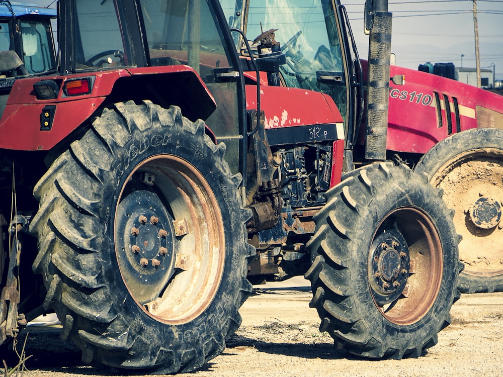 red tractor on gray sand during daytime