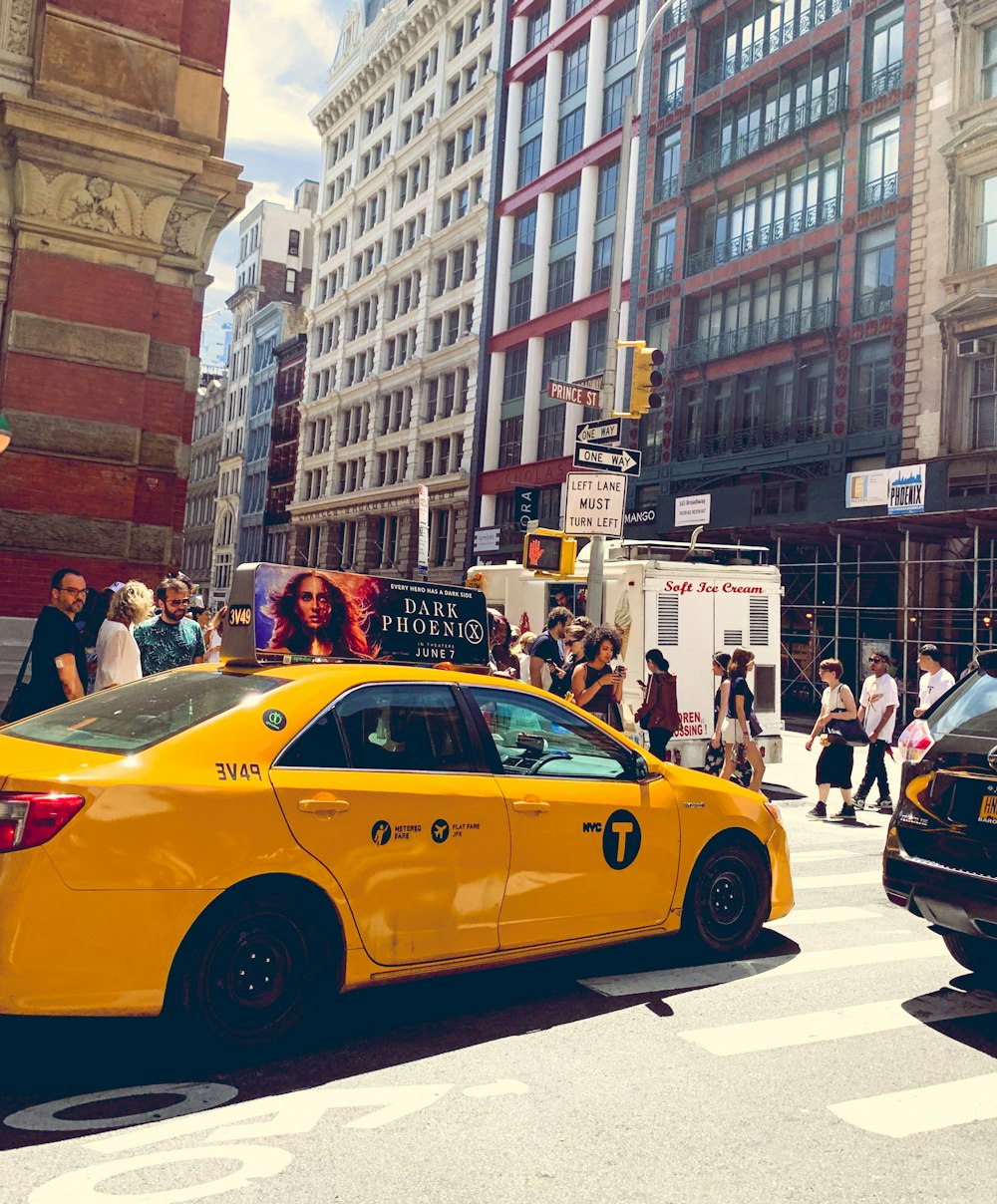 yellow taxi cab on the street during daytime
