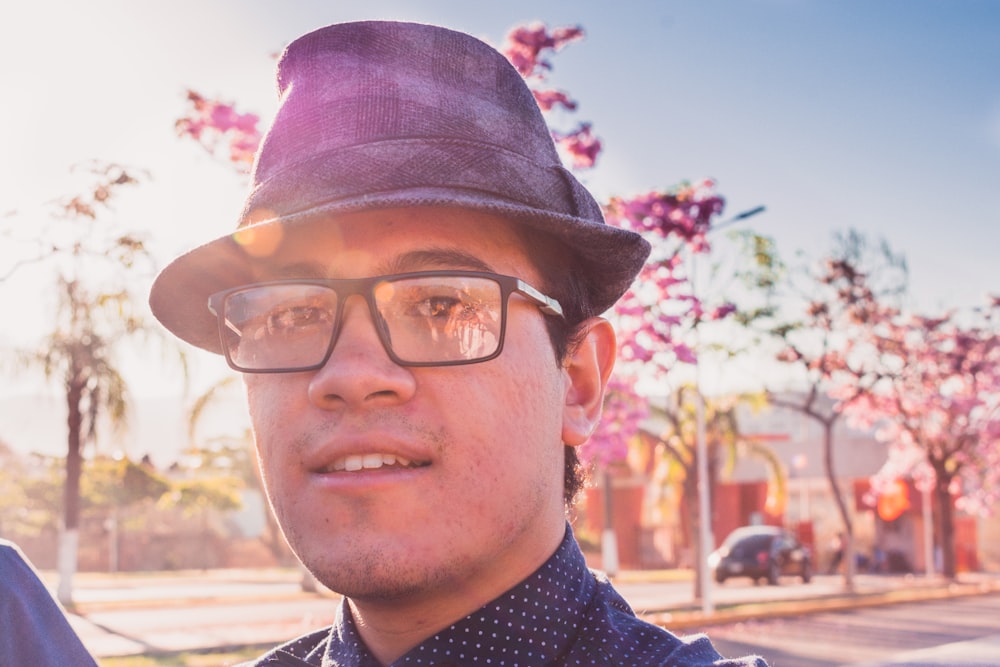 man in black framed eyeglasses and blue and white polka dot shirt