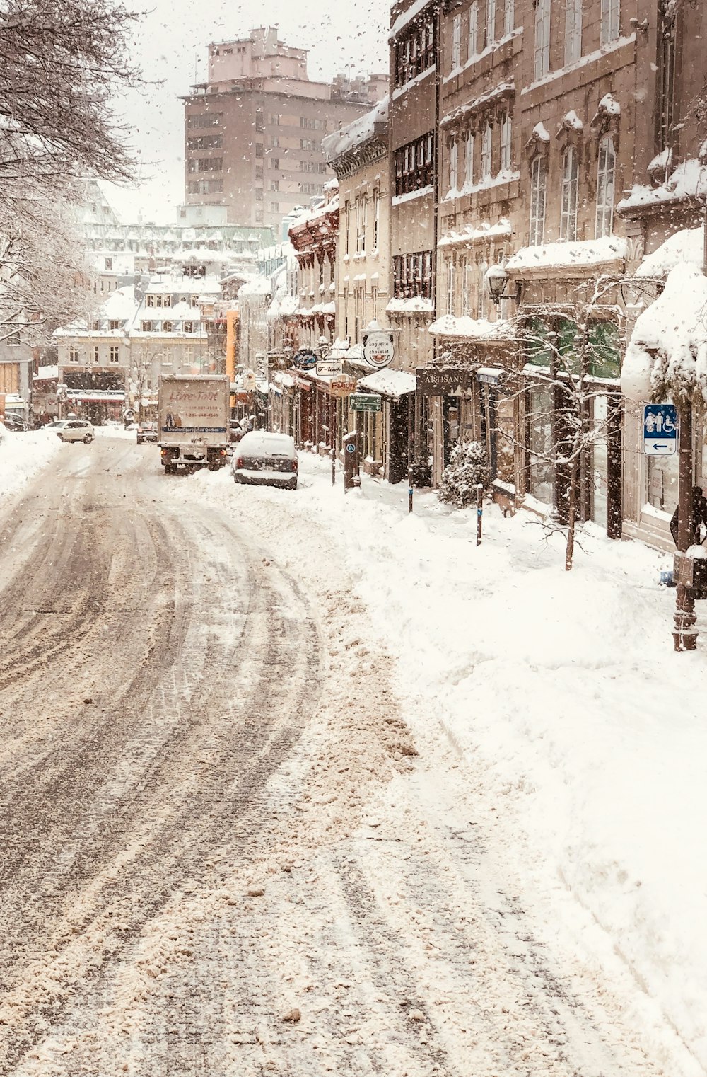 Schneebedeckte Straße zwischen den Häusern tagsüber