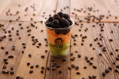 Close-up of a colorful fruit frappe topped with whipped cream and fresh berries.