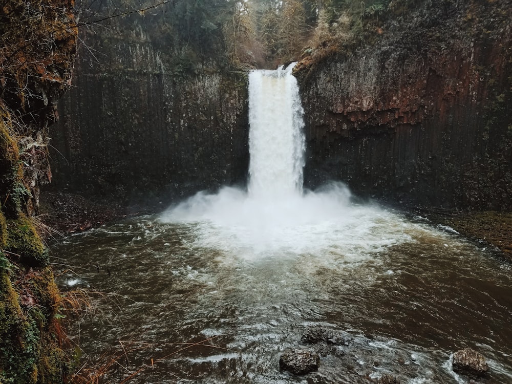 water falls on brown rocky mountain