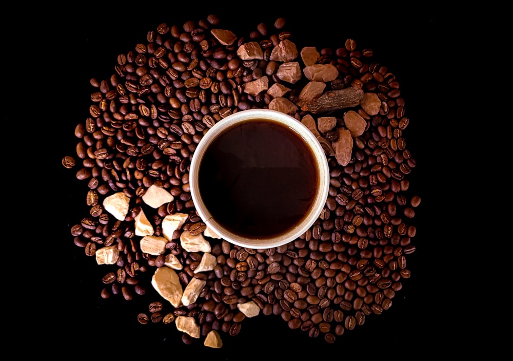 white ceramic mug on brown coffee beans