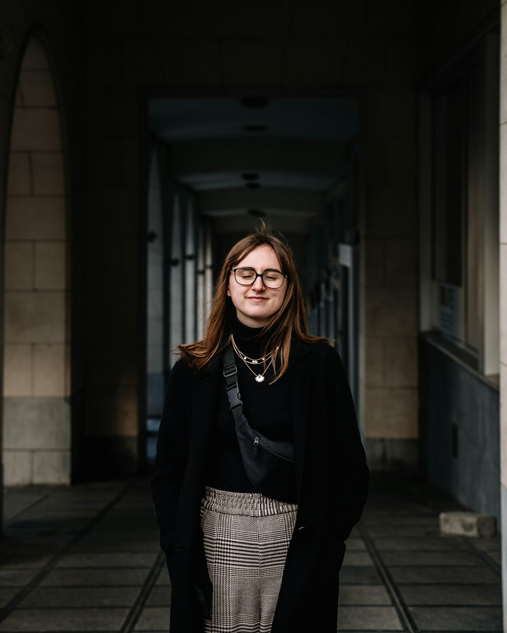 woman in black cardigan standing in front of building