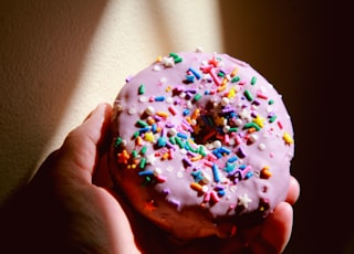person holding white and brown doughnut