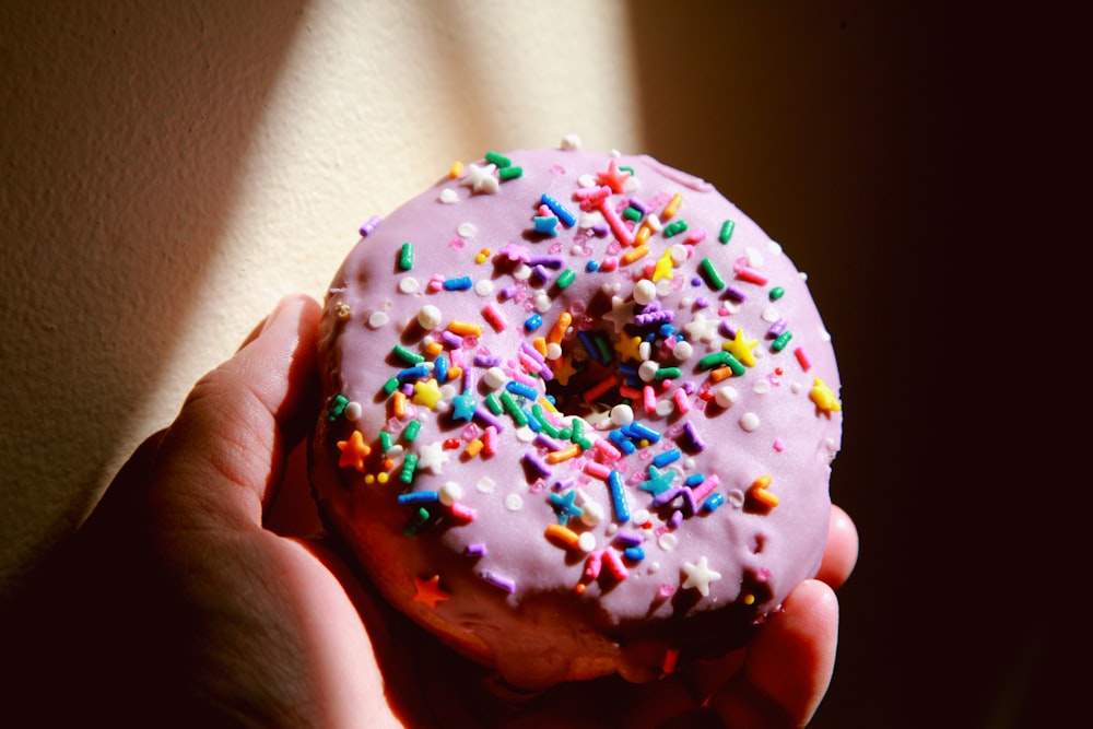 person holding white and brown doughnut