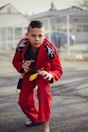 man in red and black nike jersey shirt and pants holding yellow and black smartphone