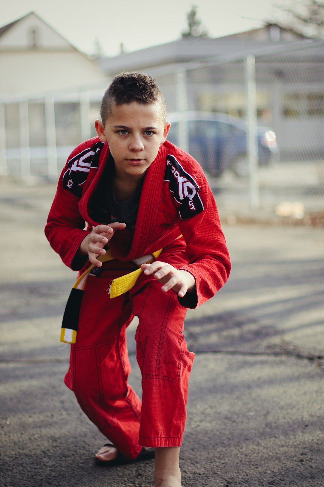 man in red and black nike jersey shirt and pants holding yellow and black smartphone