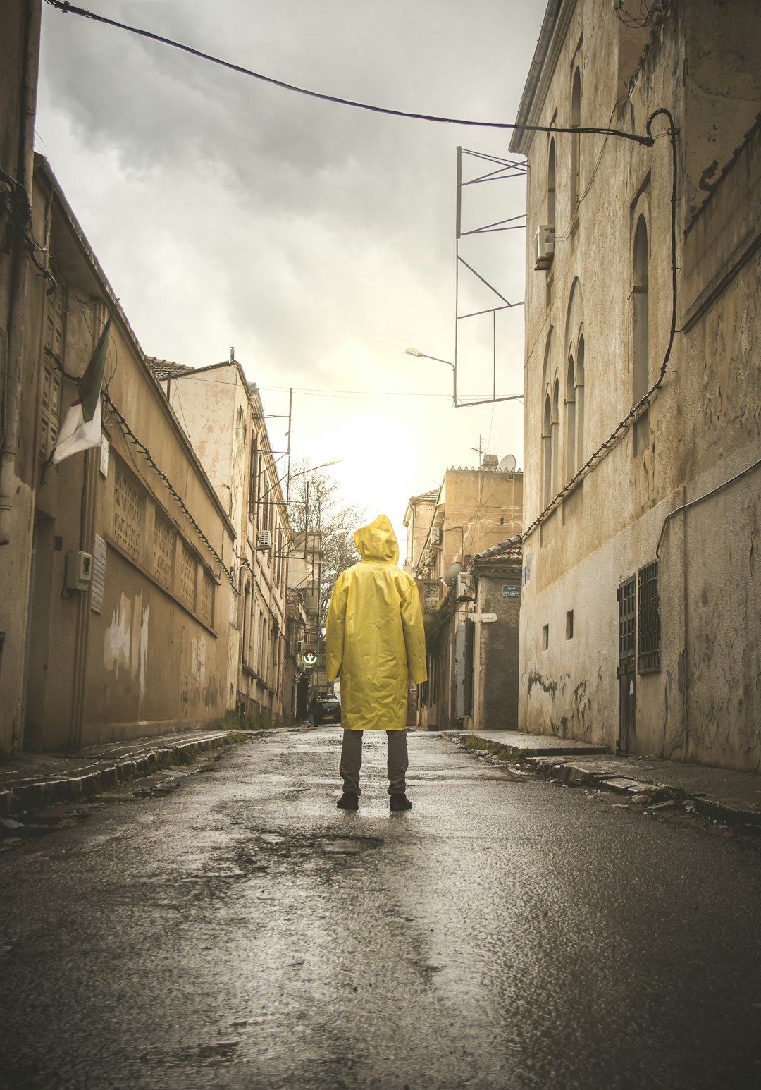 man in yellow hoodie walking on street during daytime