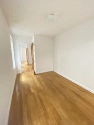 Empty, light-filled interior of a contemporary property with wooden flooring.