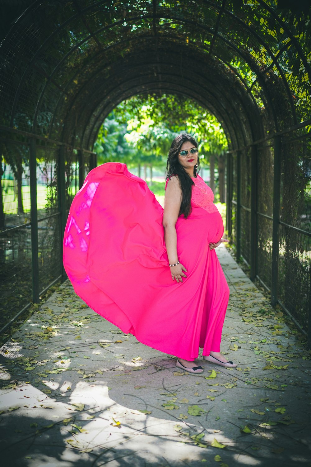 woman in pink dress standing on brown brick floor