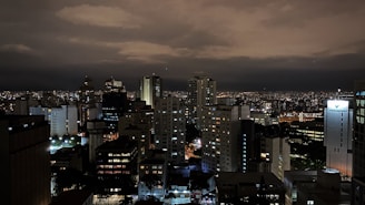 A moody cityscape at night, illuminated by bold yellow streetlights against a dark sky.