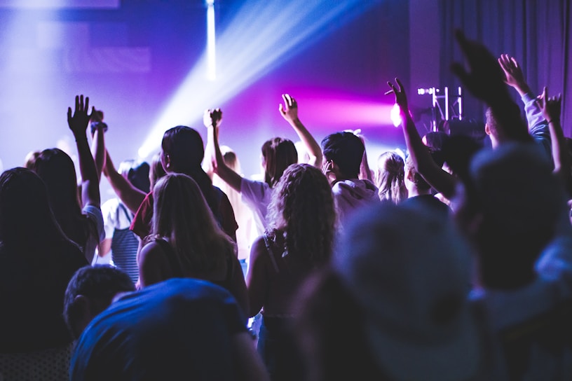 people standing on stage with purple lights