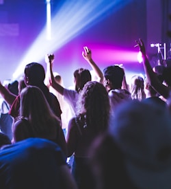 people standing on stage with purple lights