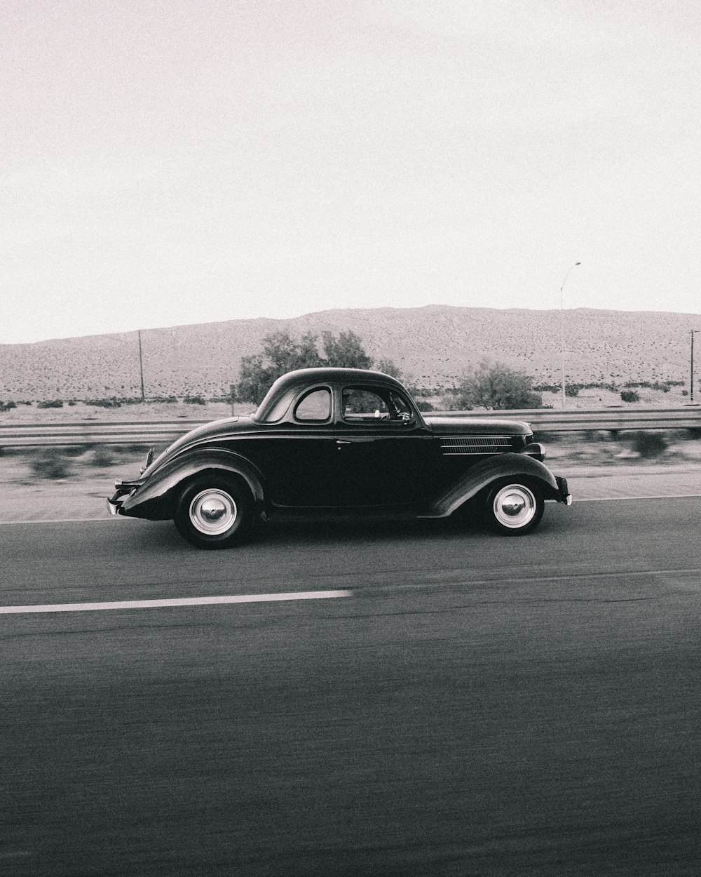 black coupe on gray asphalt road during daytime