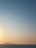 A serene landscape with a sunrise over a calm sea.