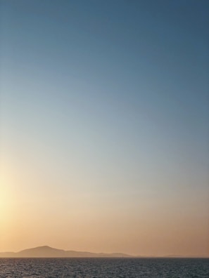 A serene landscape with a sunrise over a calm sea.