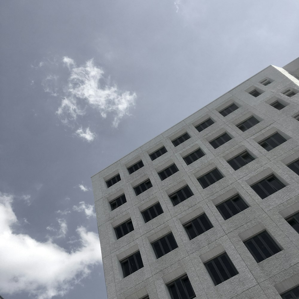 white concrete building under blue sky and white clouds during daytime