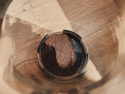 Close-up of coffee grounds being collected in a reusable container.